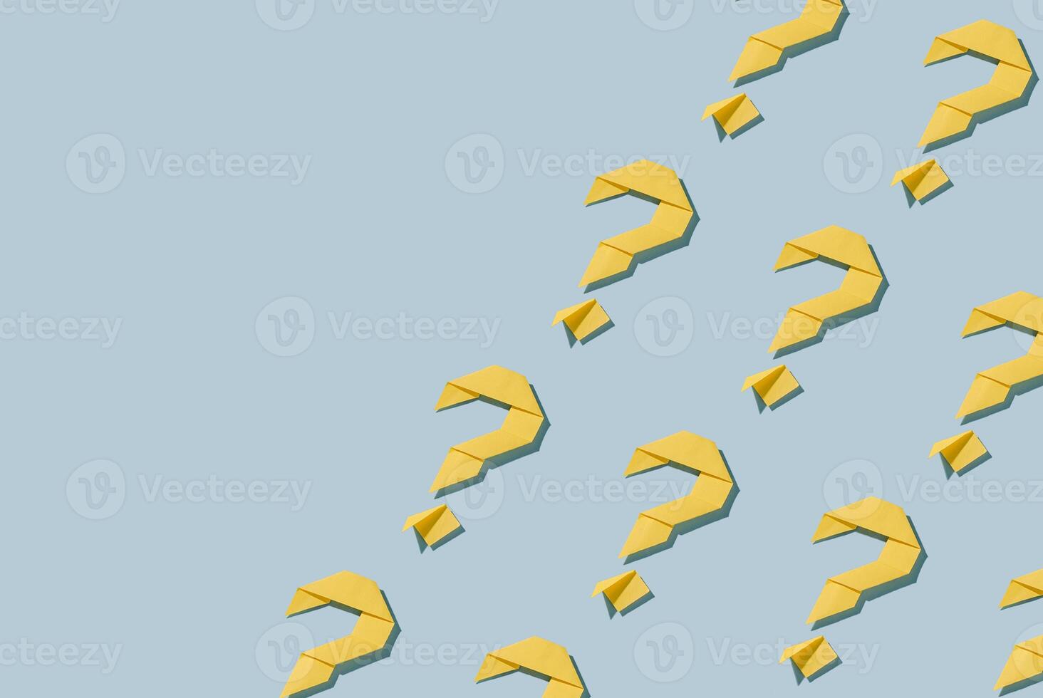 Repeat diagonal pattern of yellow paper origami question marks photo
