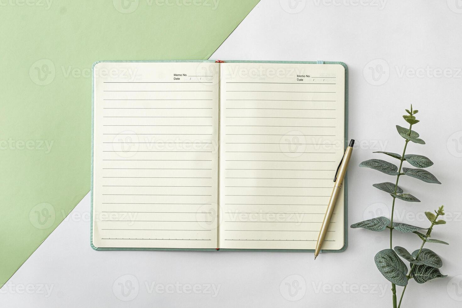 Office notebook and pen on bicolor green and white background photo