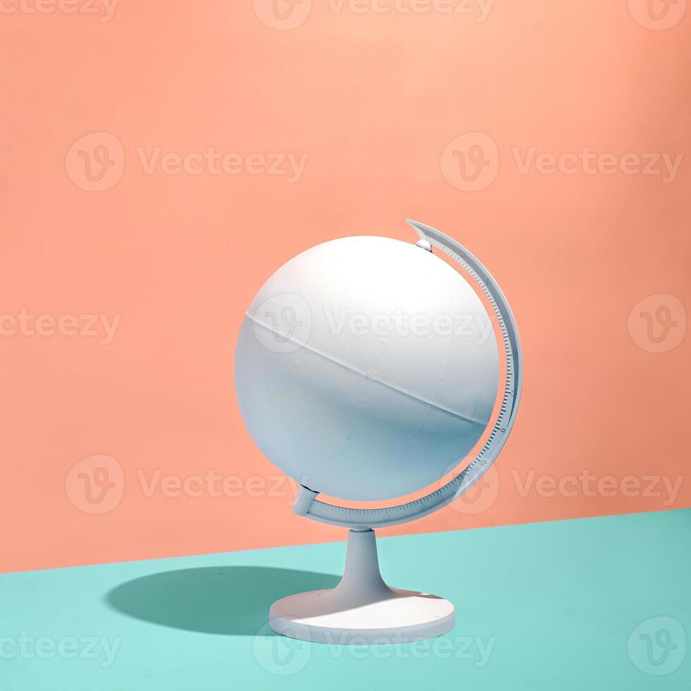 Blank white globe on a pedestal over a bicolor background photo