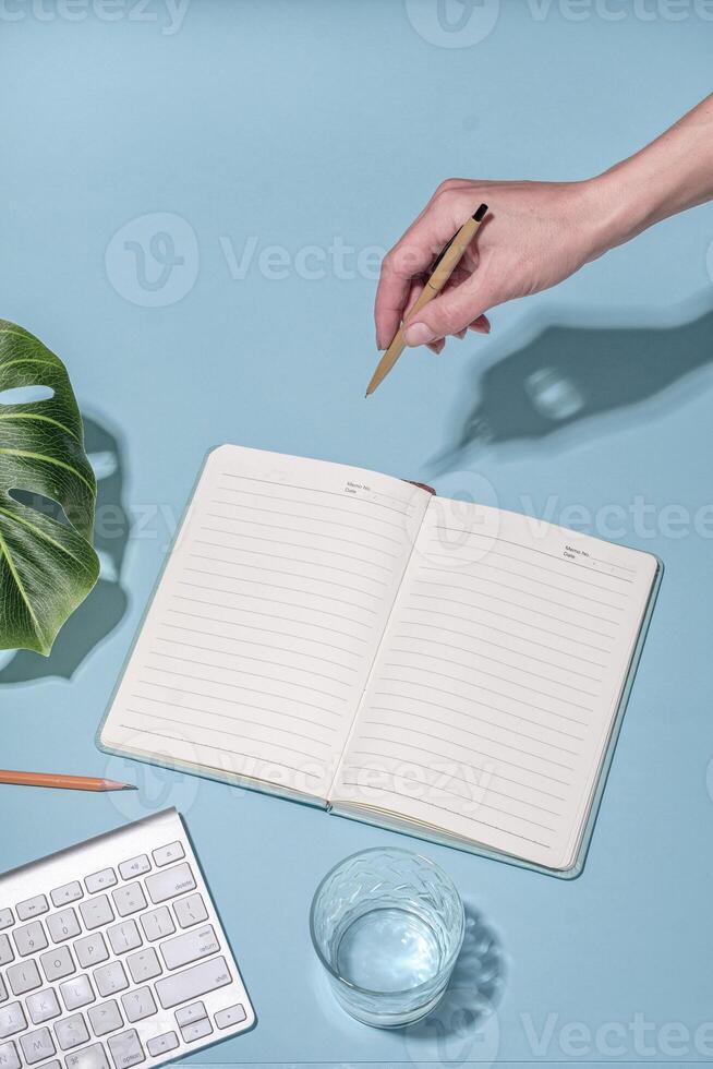 Office workstation on blue with keyboard and open notebook photo