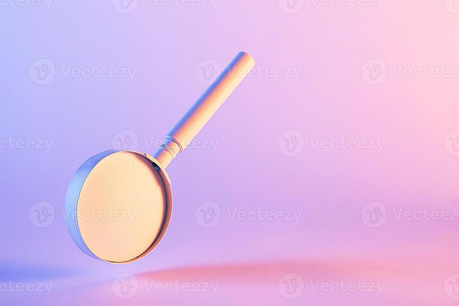 Close-up of magnifying glass floating against purple background photo