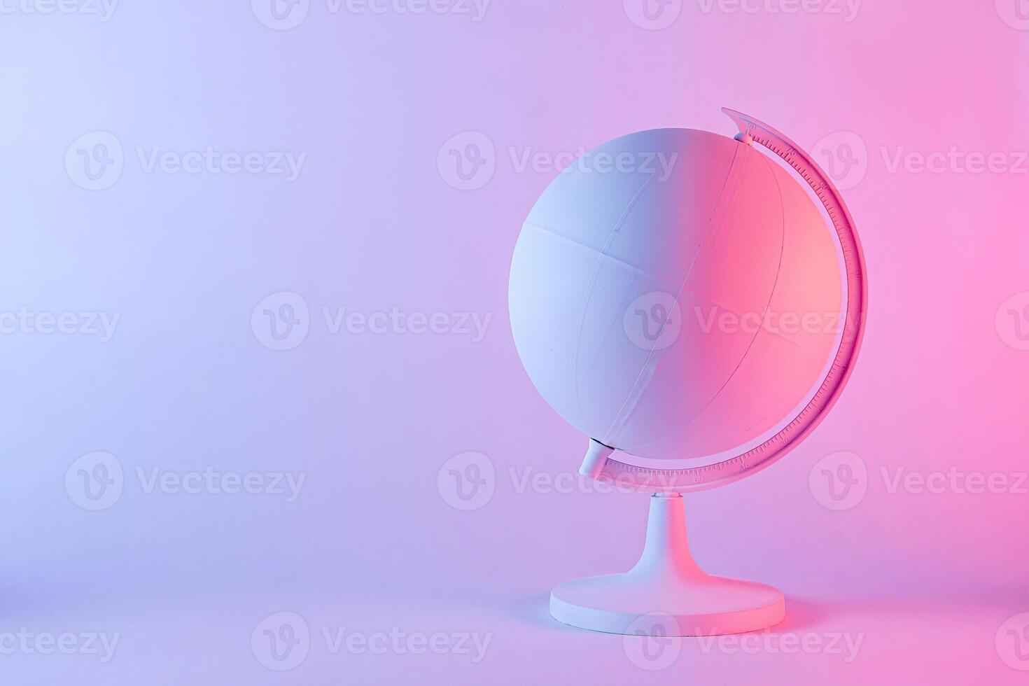 Model of a globe with blank map in pink light photo