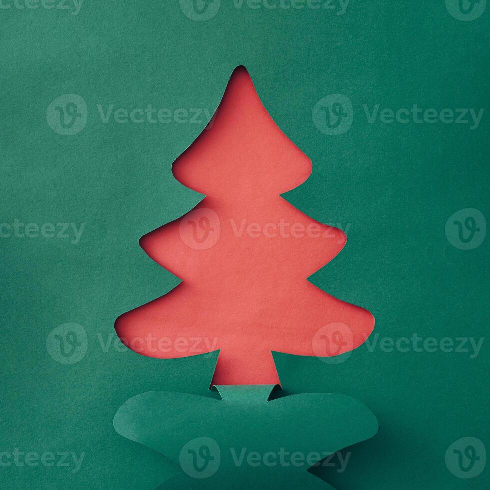 Colorful green Christmas tree paper cutout over sparkling white snow with copyspace for your holiday message or greeting in a creative handmade card photo