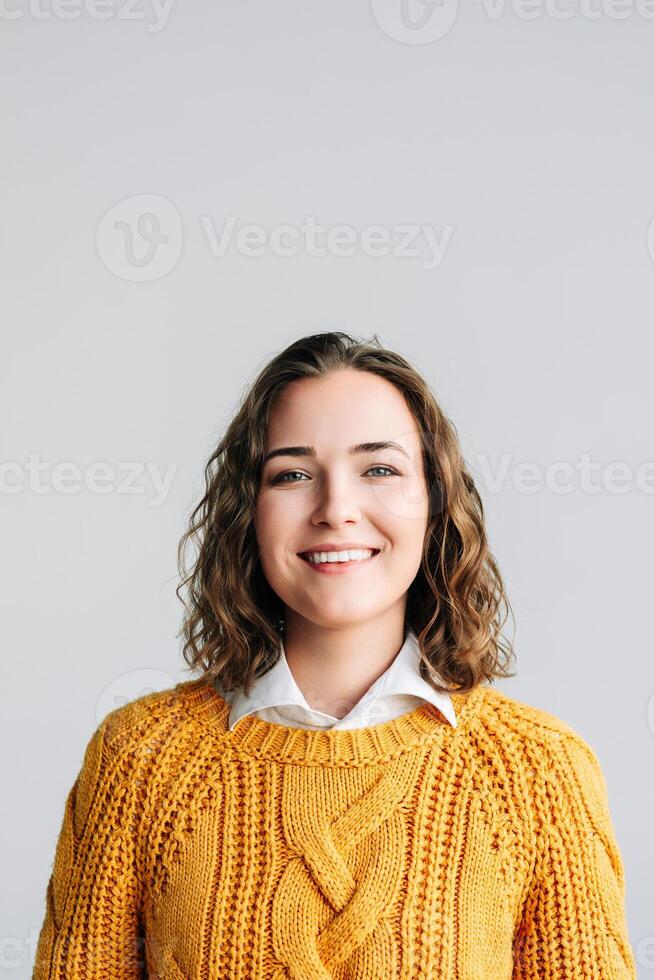 Cheerful Young Woman. Smiling, Positive, and Joyful. Happy Curly-haired Student Laughing, Looking at Camera. Isolated on White Background Close-Up Headshot Portrait for Product and Service Advertising photo