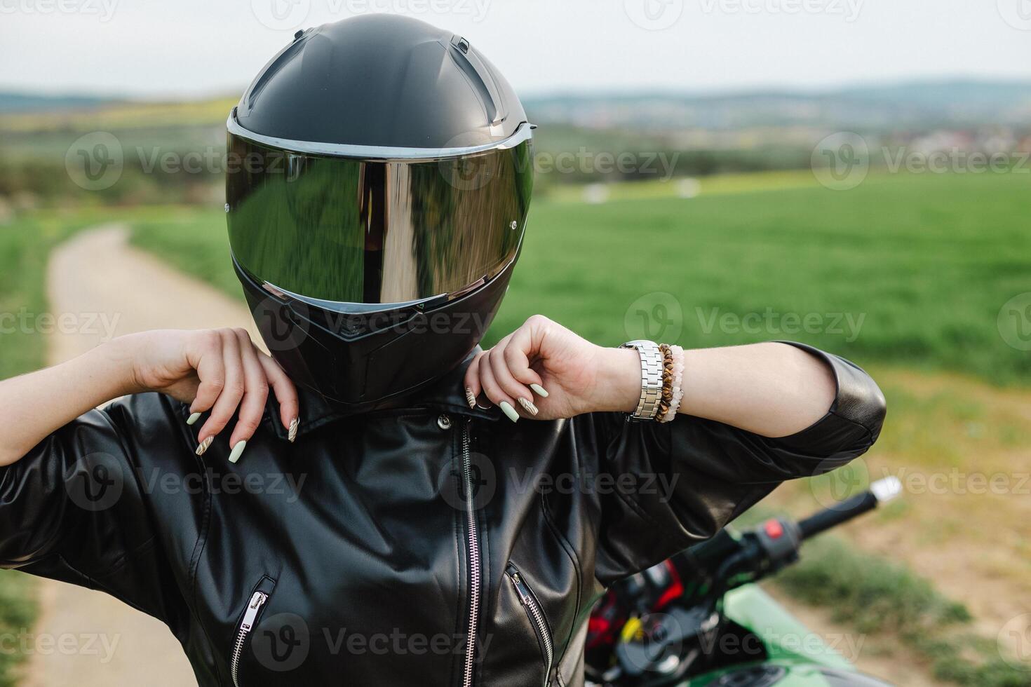Woman in Black Leather Jacket with Helmet. Stylish woman in a black leather jacket and helmet, standing confidently. Perfect for themes of safety, biker lifestyle, or modern fashion with an edge. photo