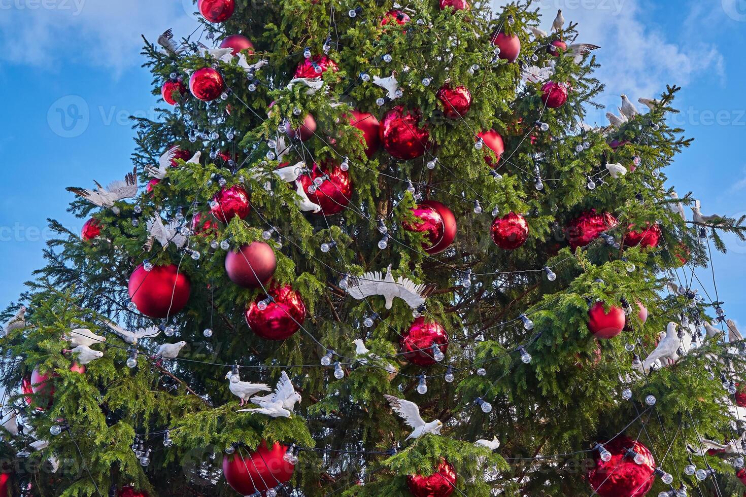 Decorated Christmas Tree with Red Ornaments and White Dove Figurines, low angle view photo