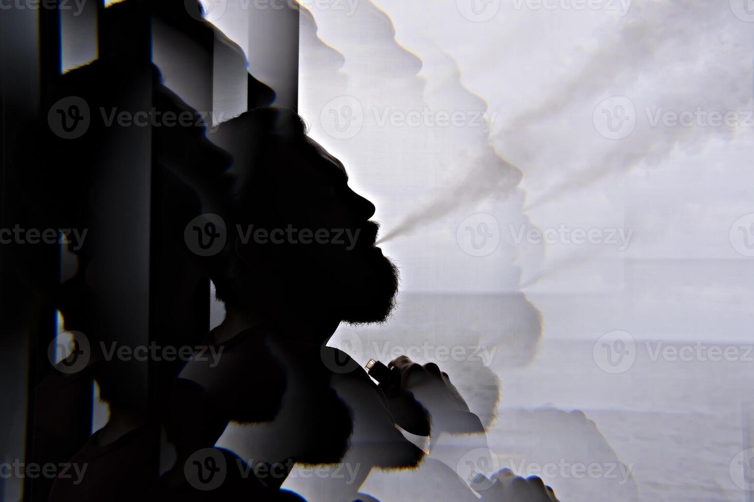 Silhouette of bearded vaper man with cloud of vapor, black and white with kaleidoscope effect photo