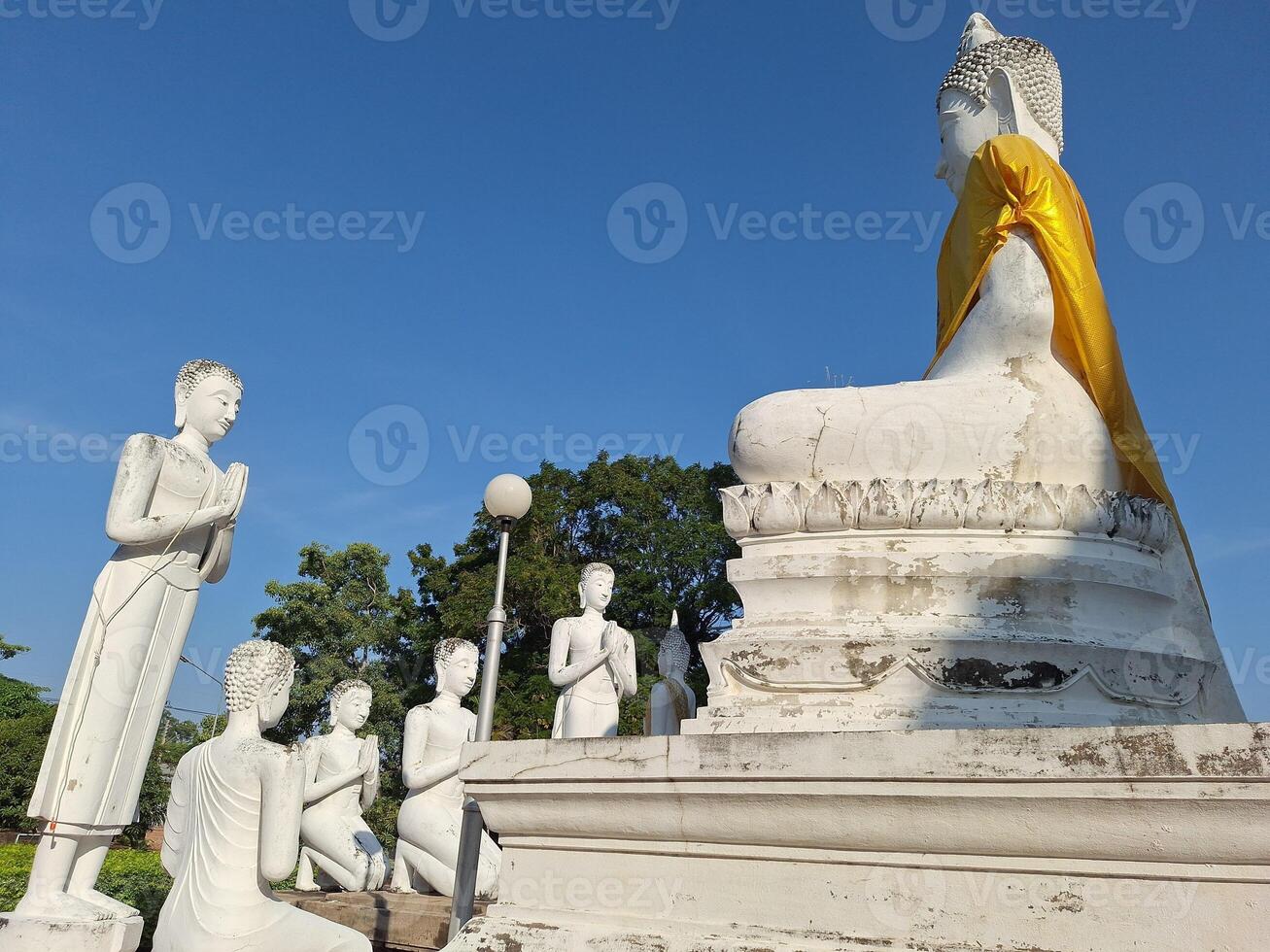 Old white stucco Buddha images in meditation and standing positions at famous tourist attractions photo