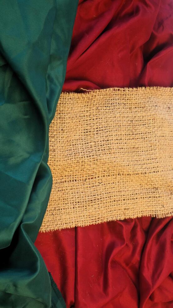 A rustic vintage burlap featuring green and red plain fabric, copy space for minimalist christmas greeting design textured background photo