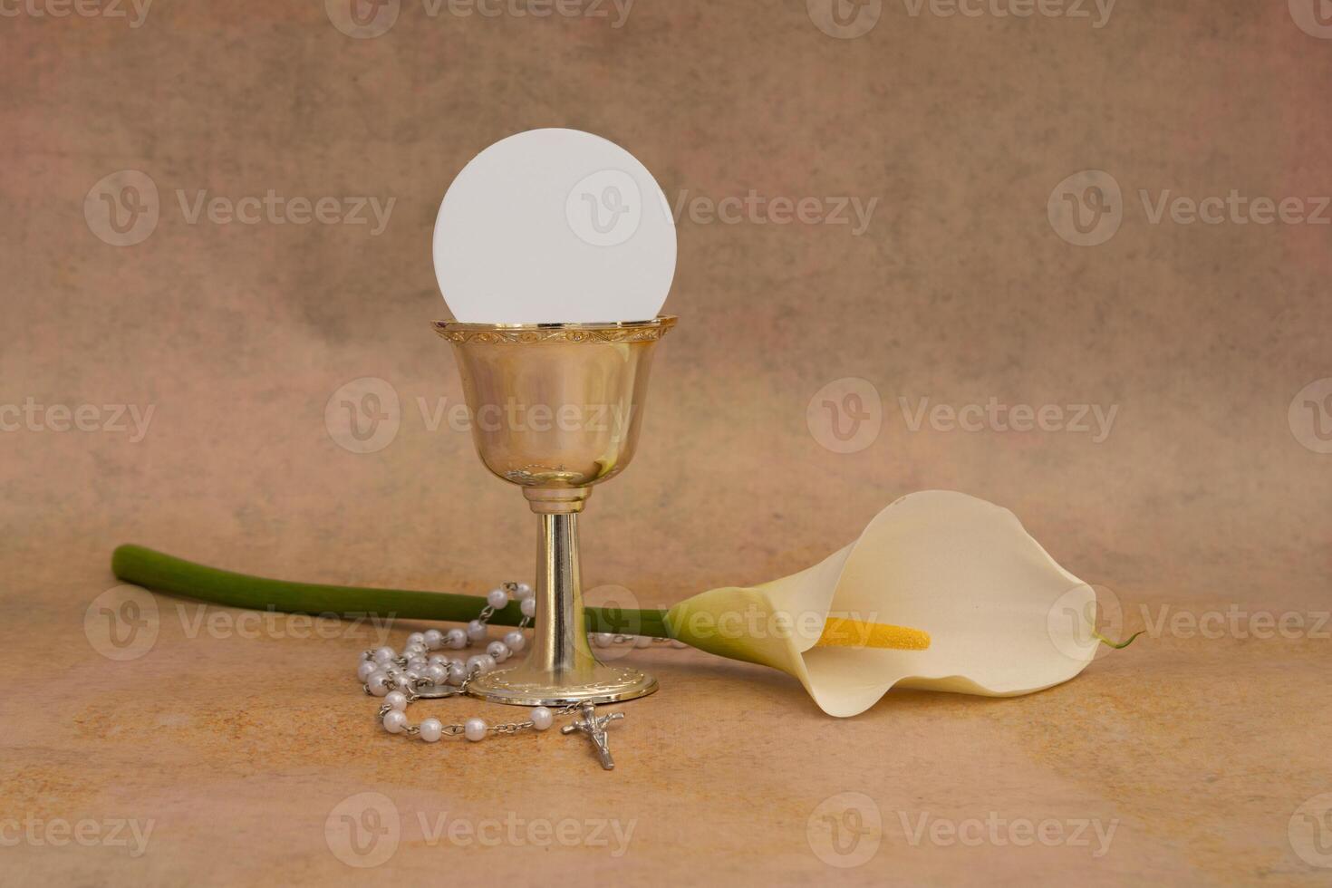 Chalice with white cala host and a rosary, symbols of Christian communion photo