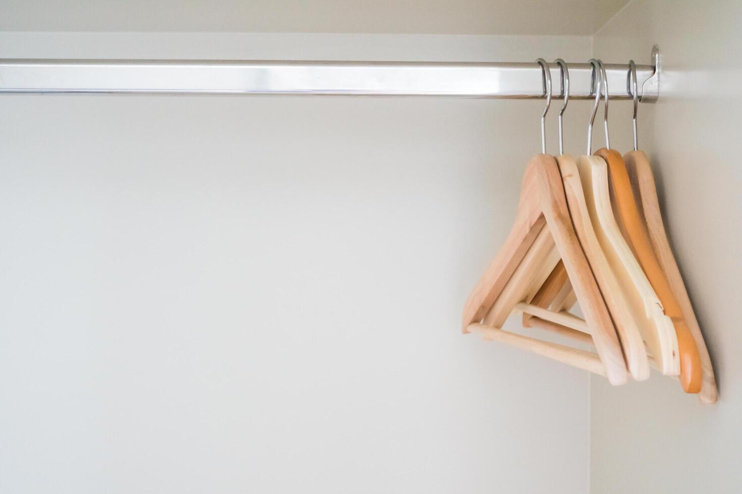 Clothes hangers on a rack in a closet photo