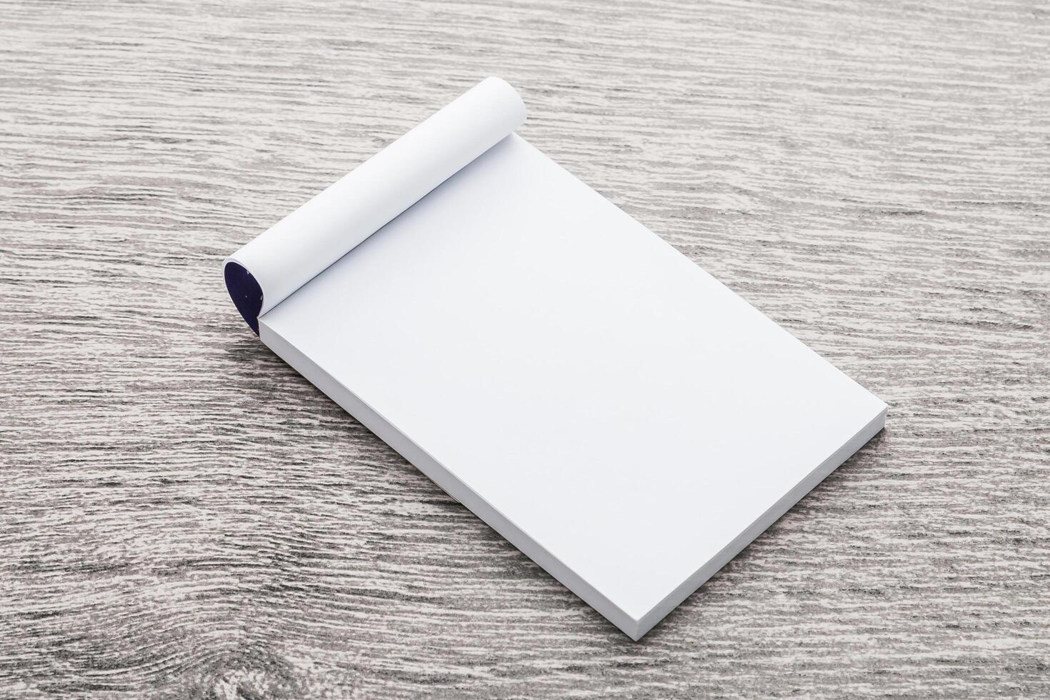 Blank notepad on wooden table top view photo