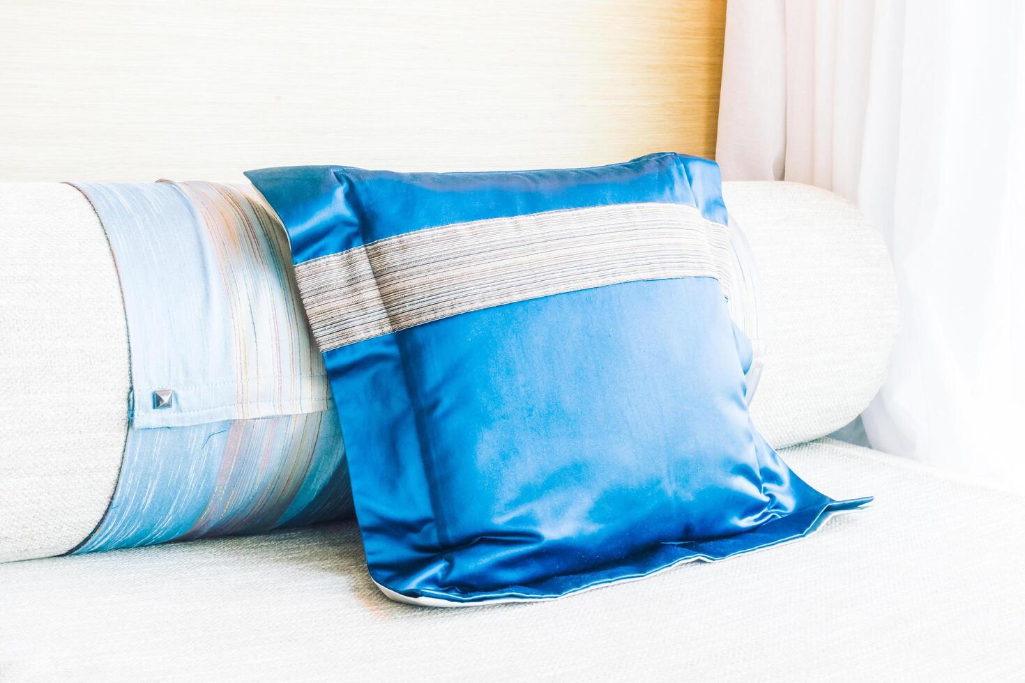 A blue pillow on a couch with a white pillow photo