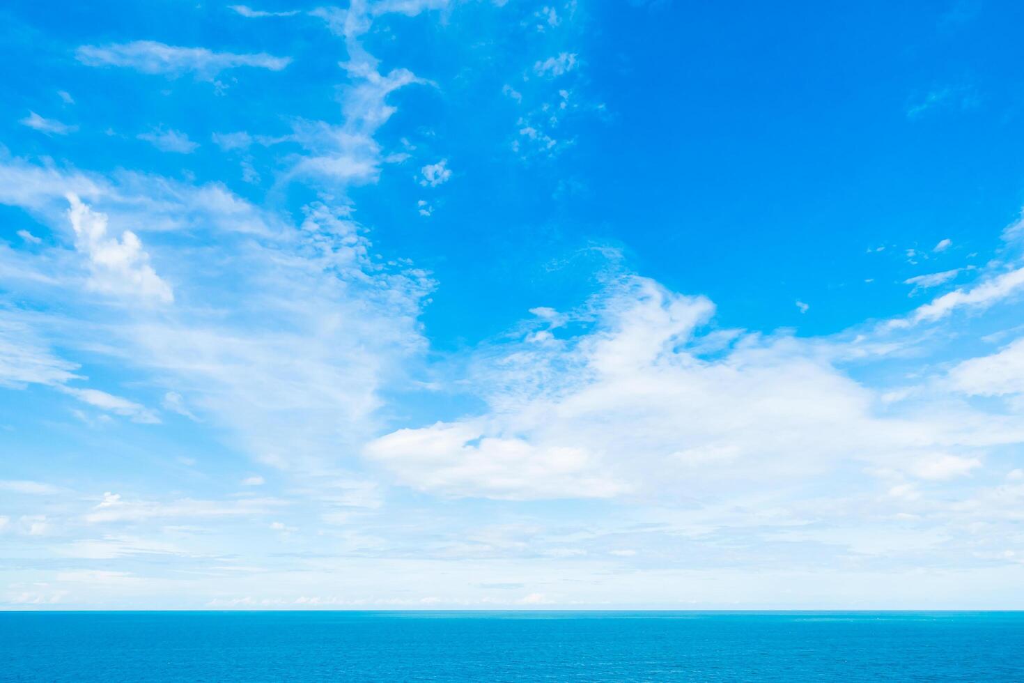 A blue sky with clouds over the ocean photo