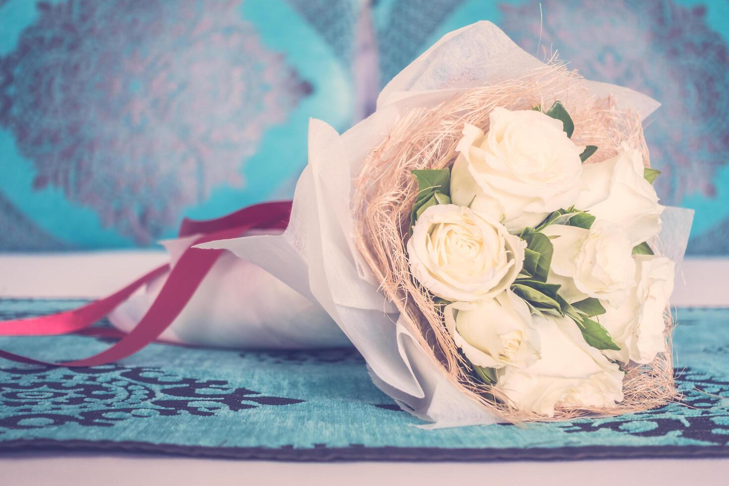 A bouquet of white roses on a bed photo