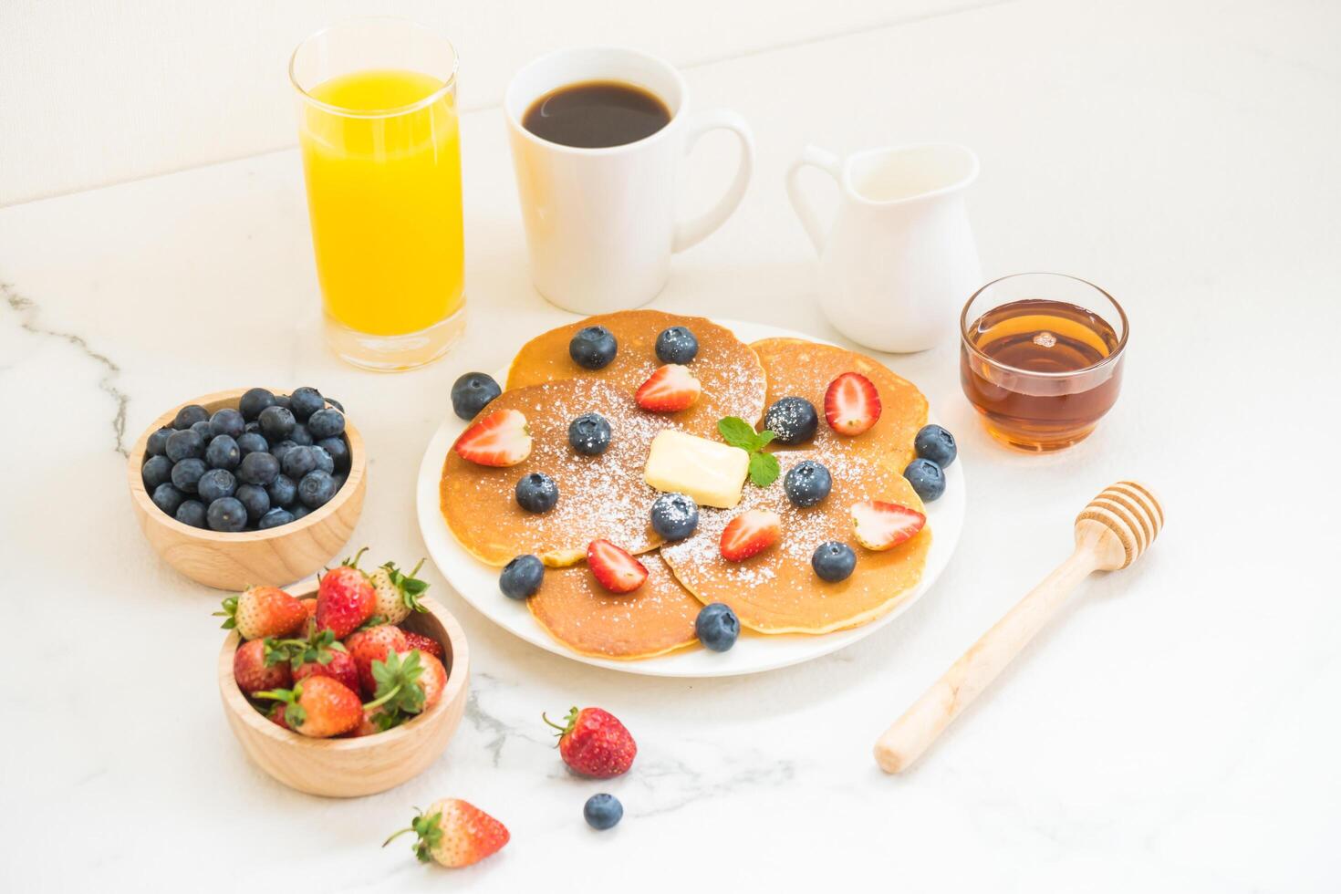 A breakfast with pancakes, berries and orange juice photo