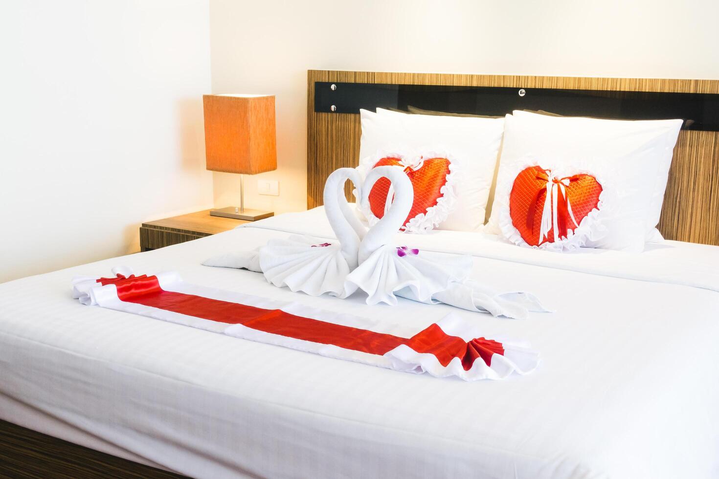 A bed with towels on it and a heart shaped pillow photo