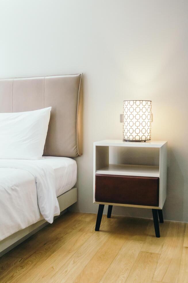 A bed with a nightstand and a lamp on it photo