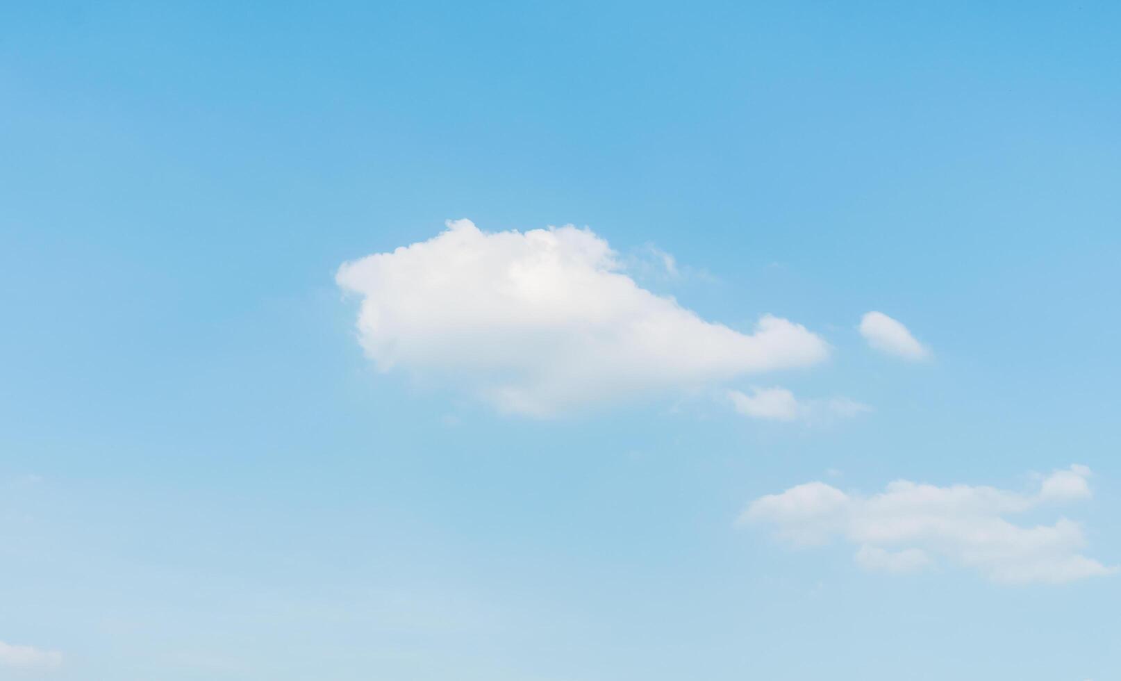 A large field with a large white cloud in the sky photo