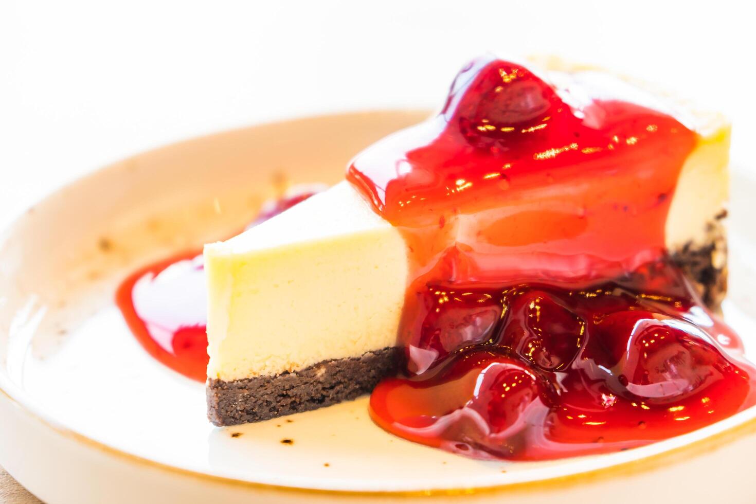 A piece of cheesecake with cherry sauce on top photo