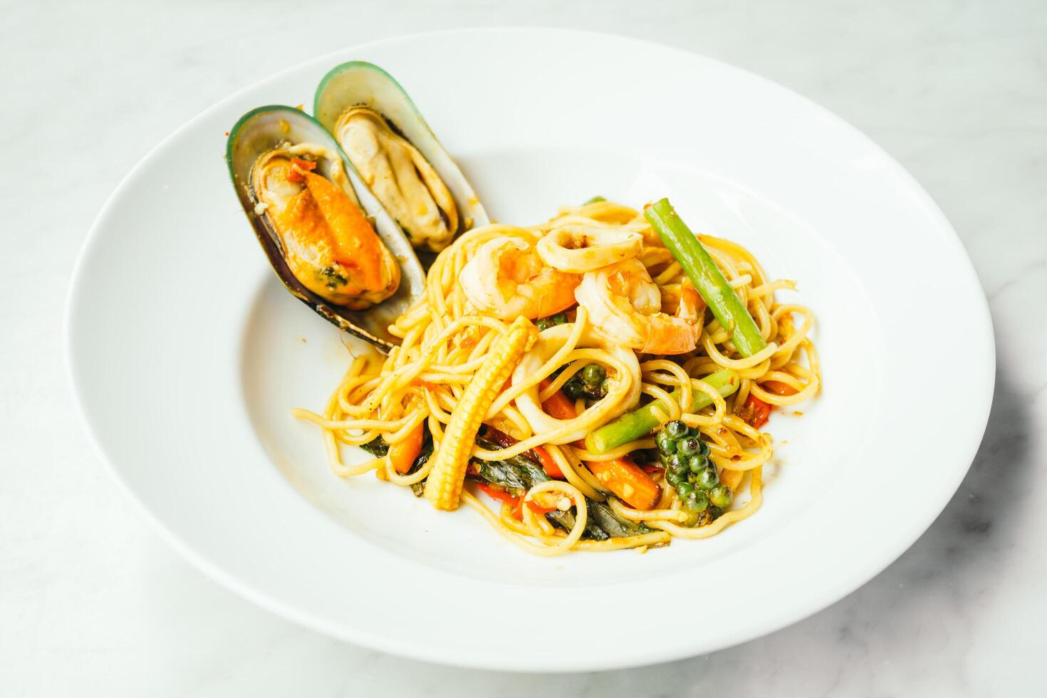 A plate of pasta with seafood and vegetables photo
