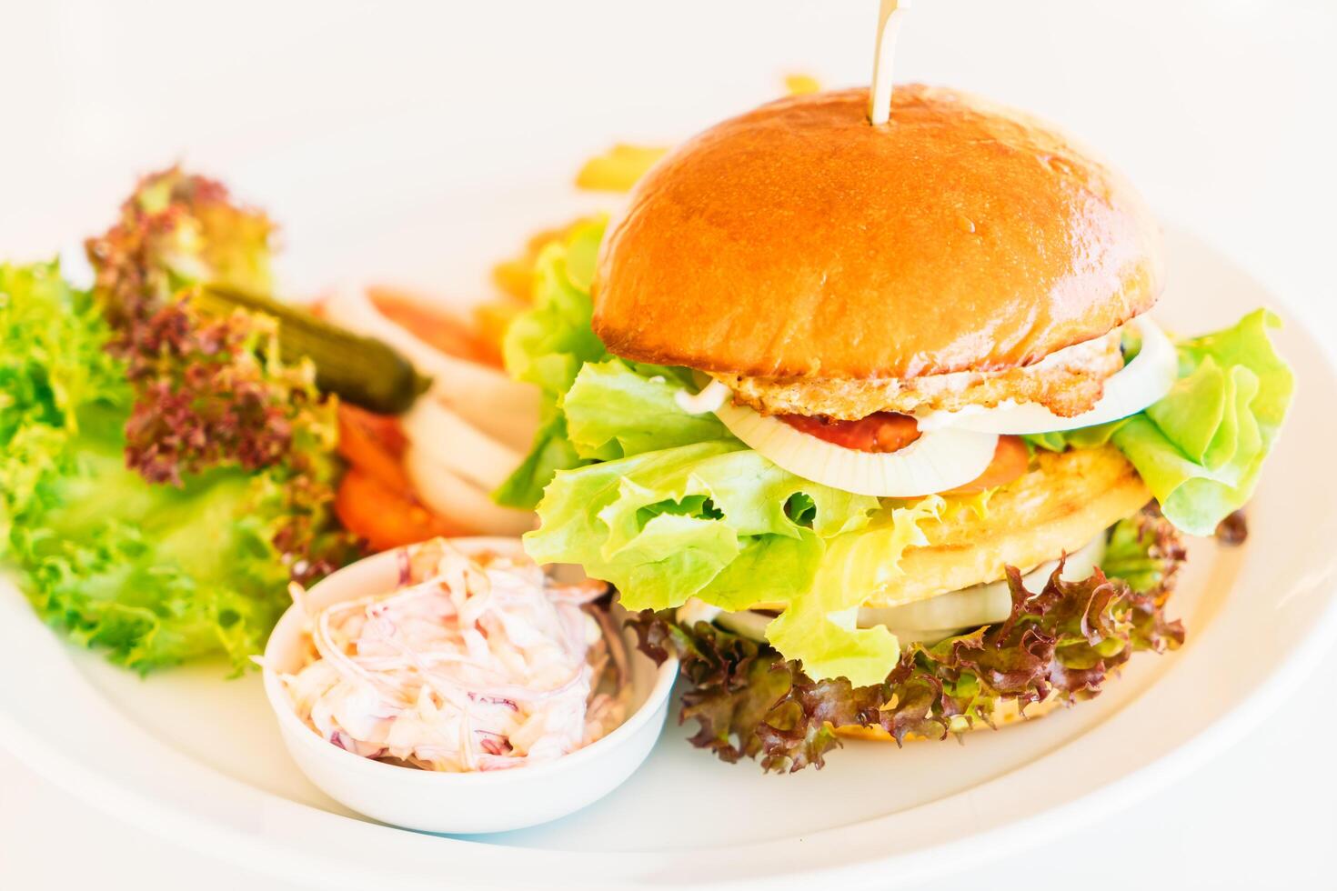 A plate with a burger and some vegetables on it photo