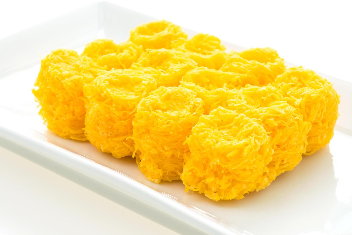 A plate of yellow rice balls on a white surface photo