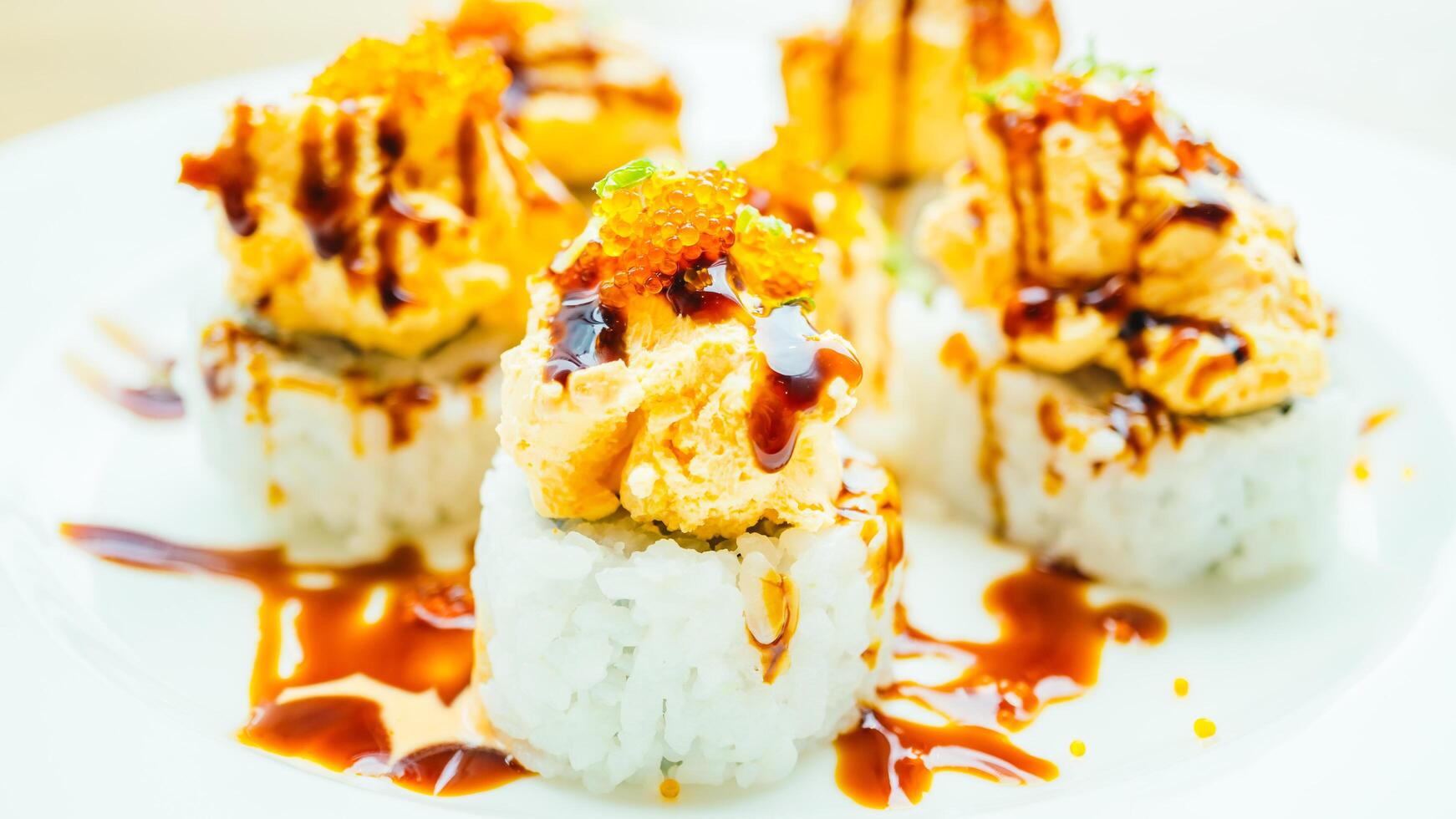A plate of sushi with sauce and orange slices photo