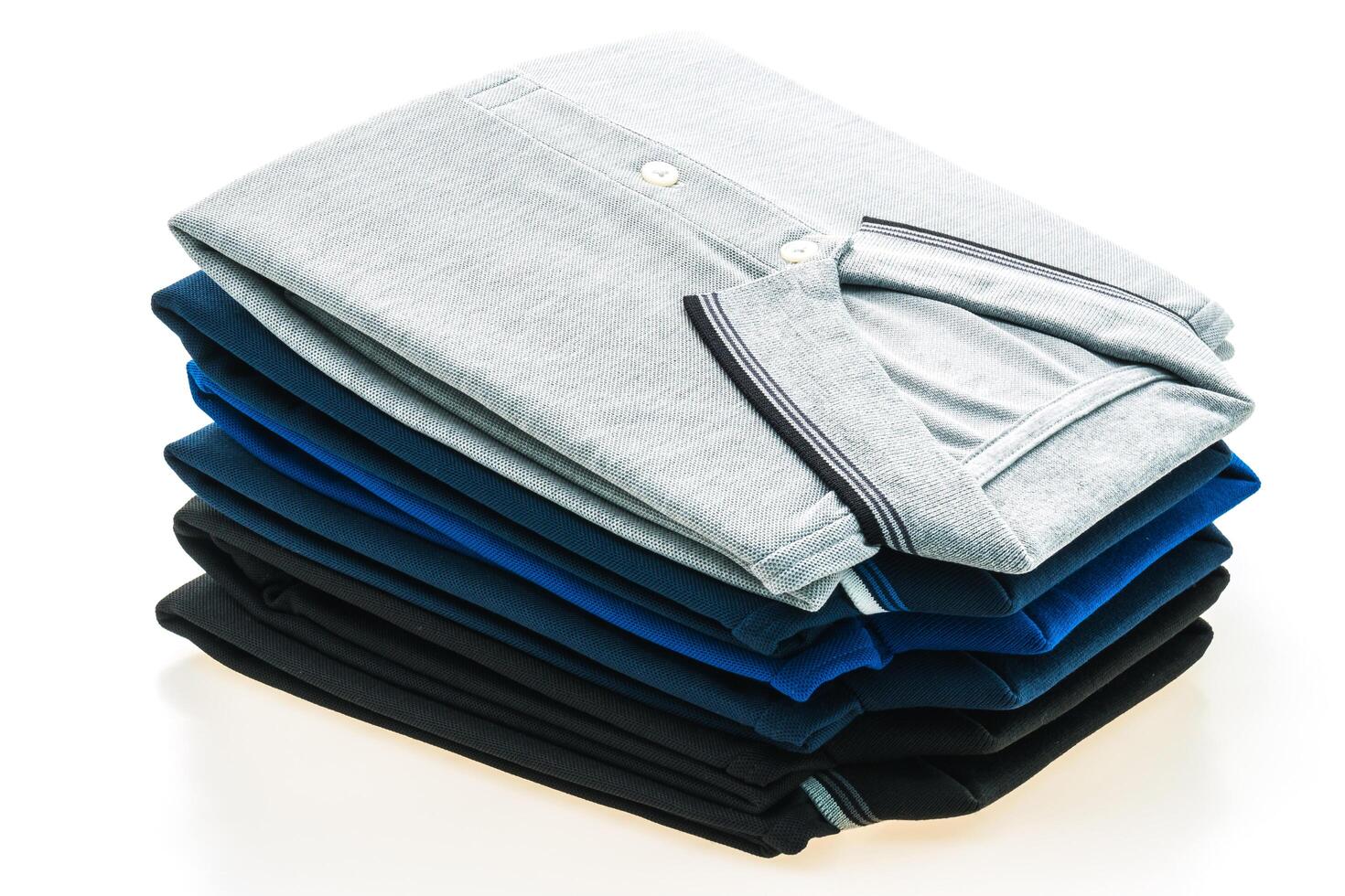 A stack of four different colored shirts photo
