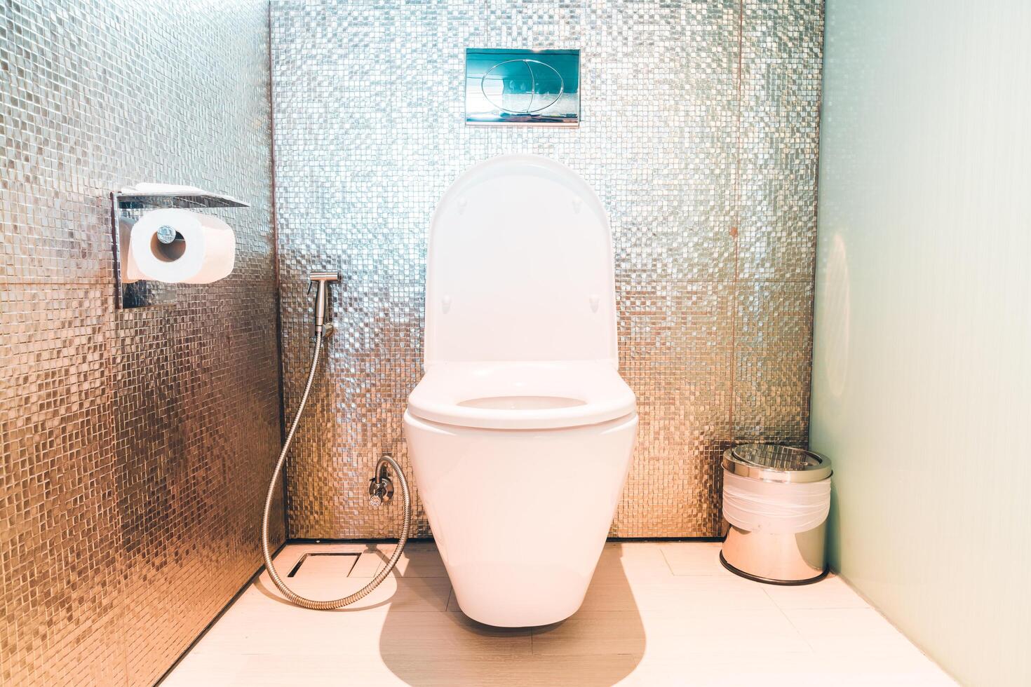 A toilet in a bathroom with a wall of mirrors photo