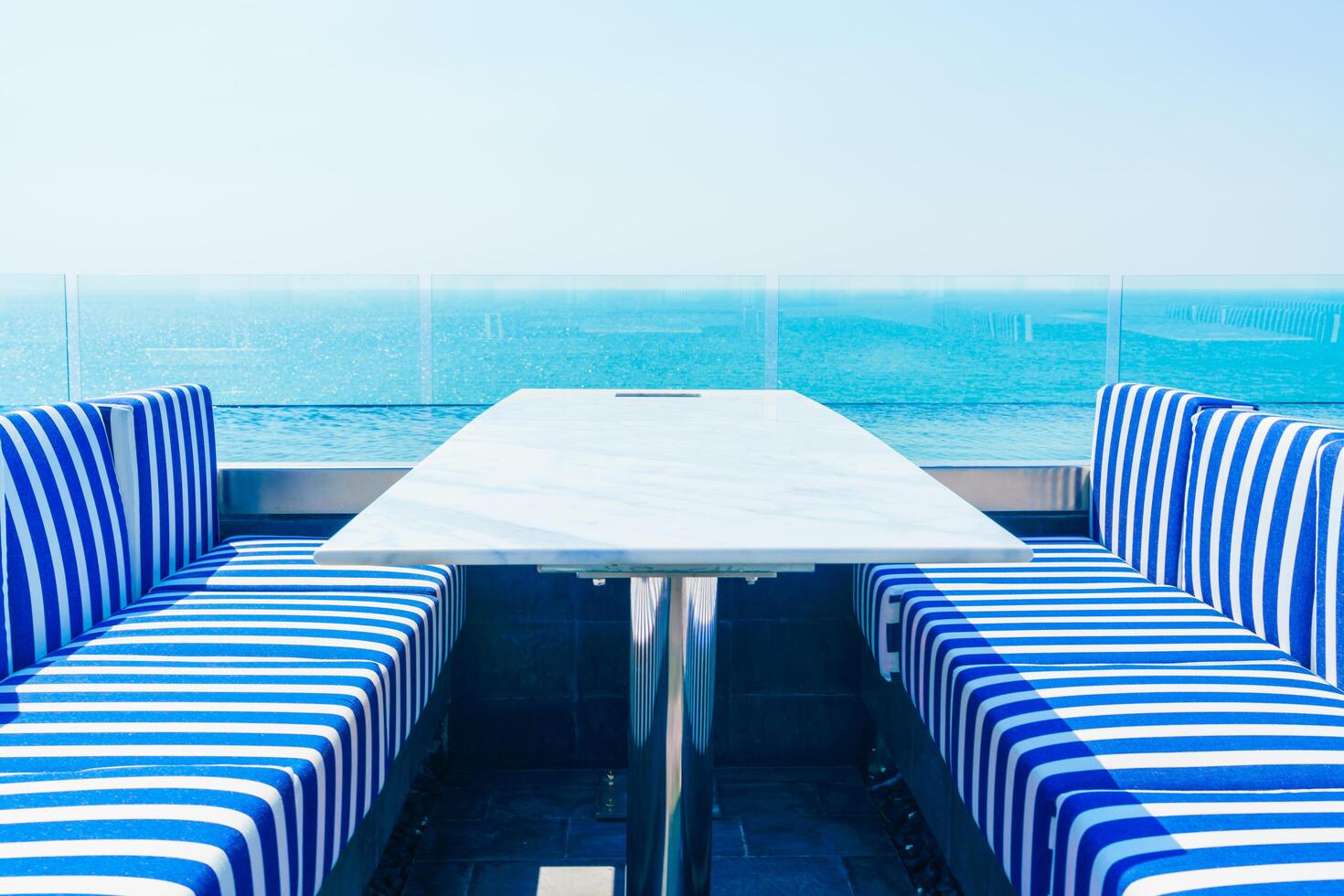 A table and chairs on a balcony overlooking the ocean photo