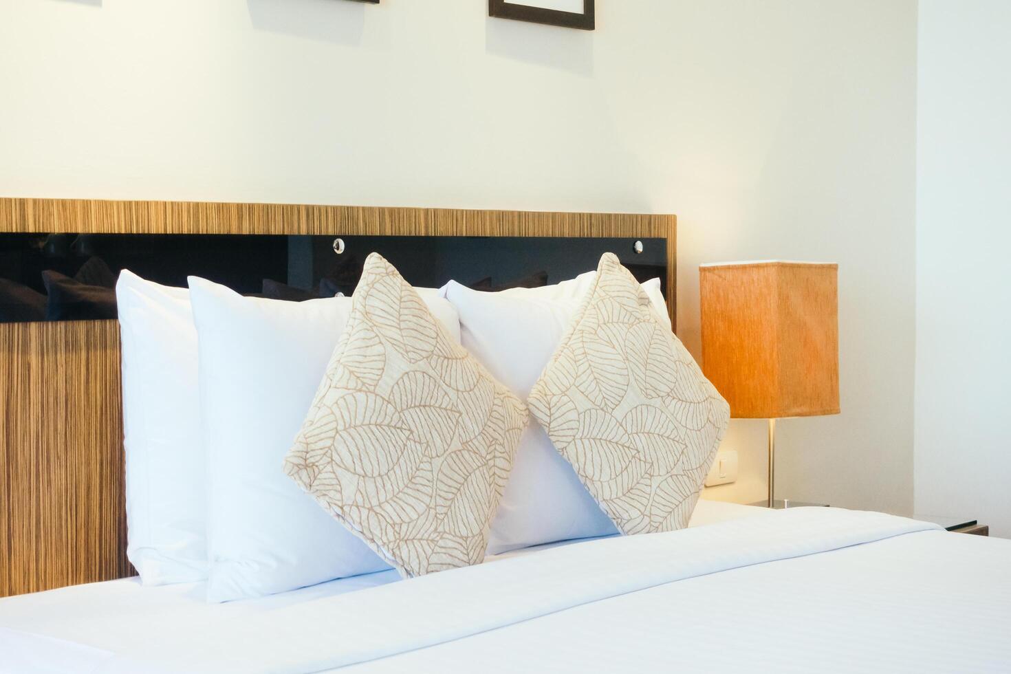 A white bed with two pillows and a lamp photo