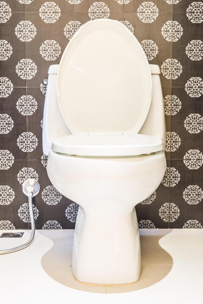 A white toilet with a black and white pattern photo