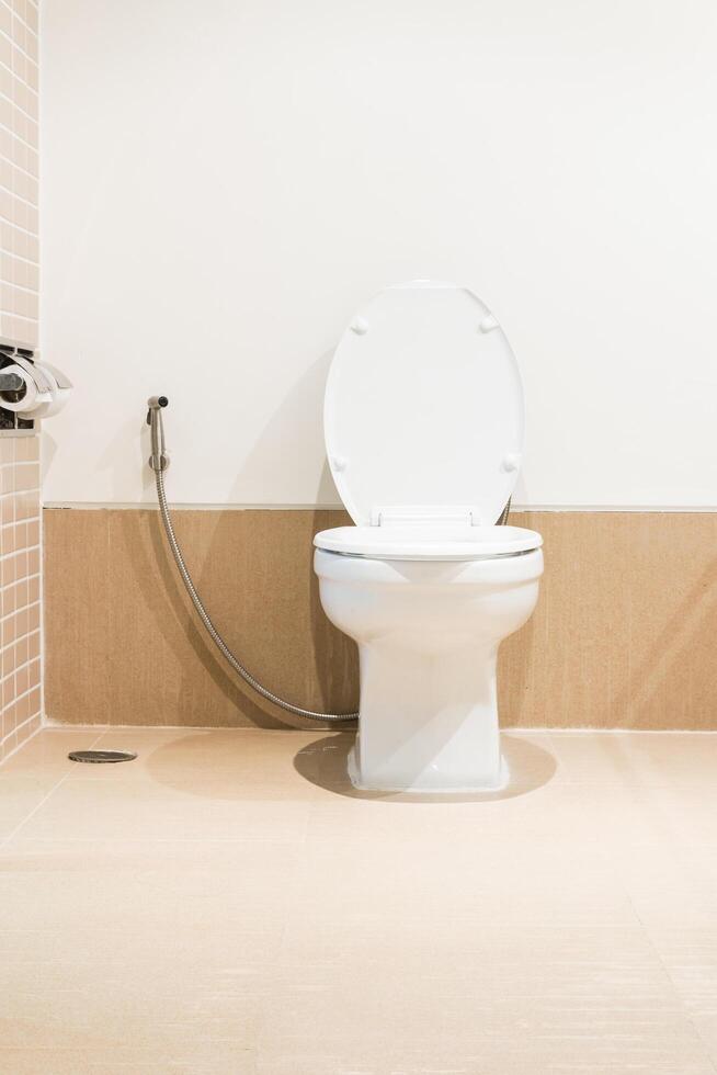A white toilet sitting in a bathroom with a shower photo