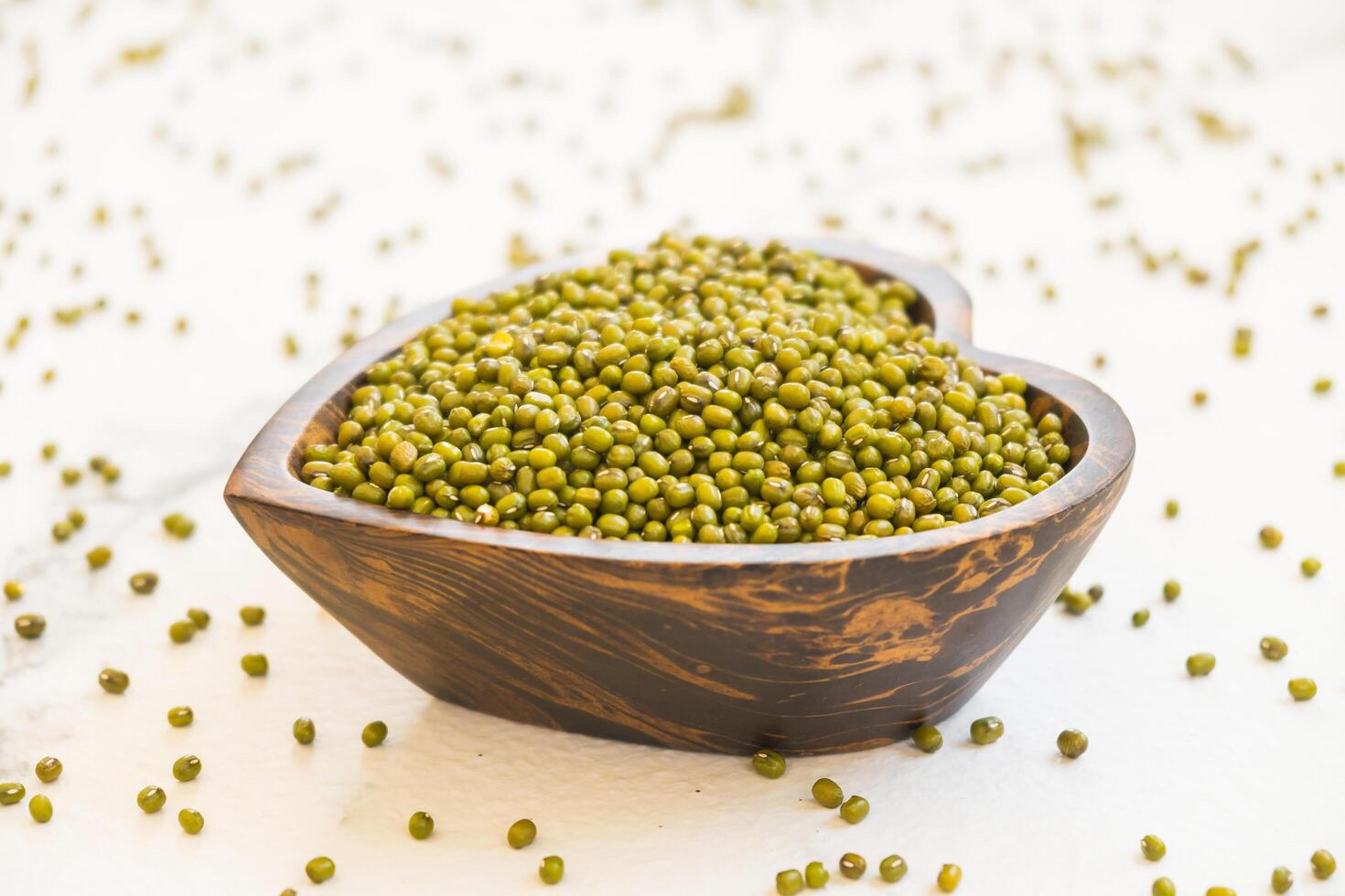 A wooden bowl filled with green seeds photo