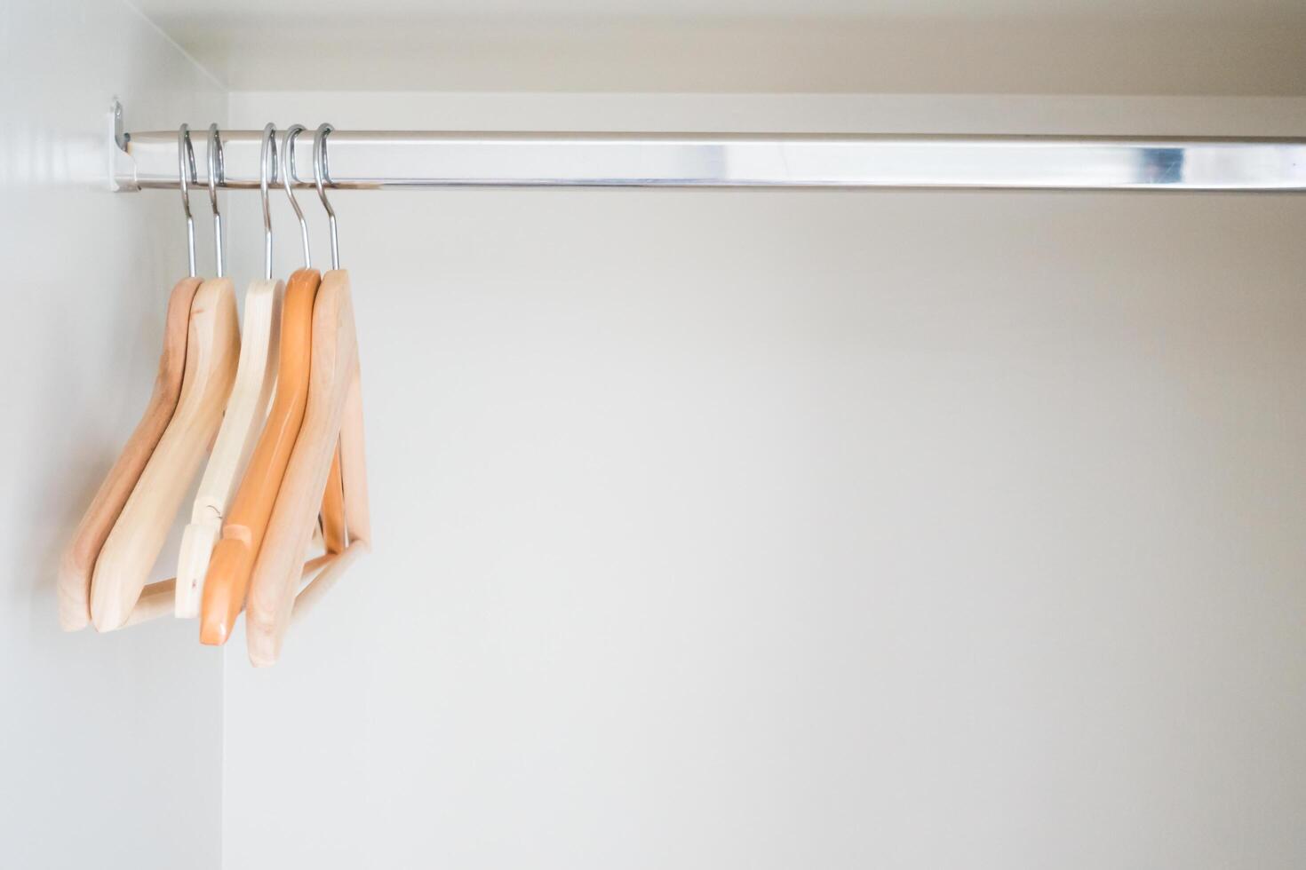 Clothes hangers on a rack in a closet photo