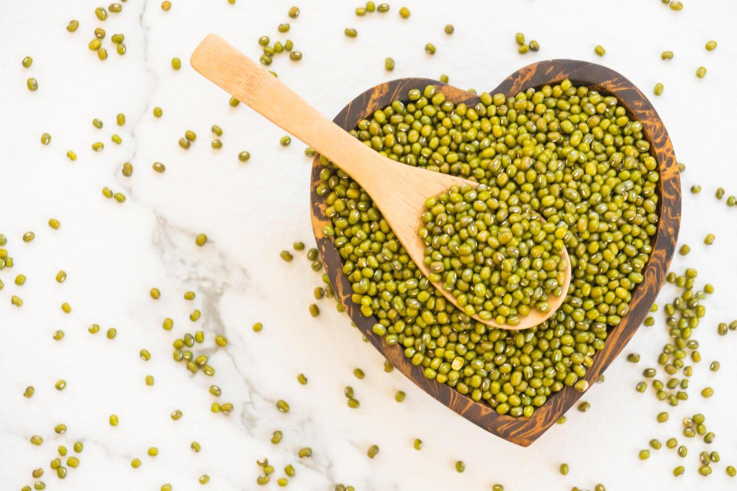 Green peas in a heart shape on a white background photo
