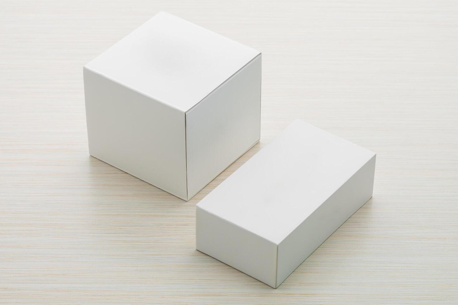Two white boxes on a wooden surface photo