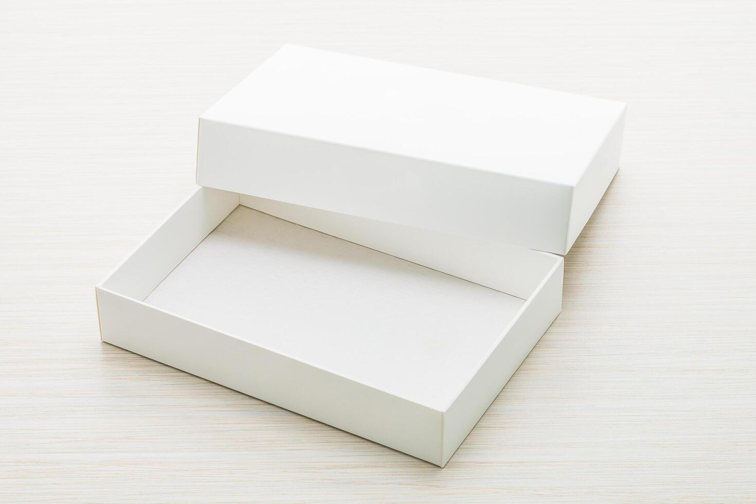 White box with lid on wooden surface photo