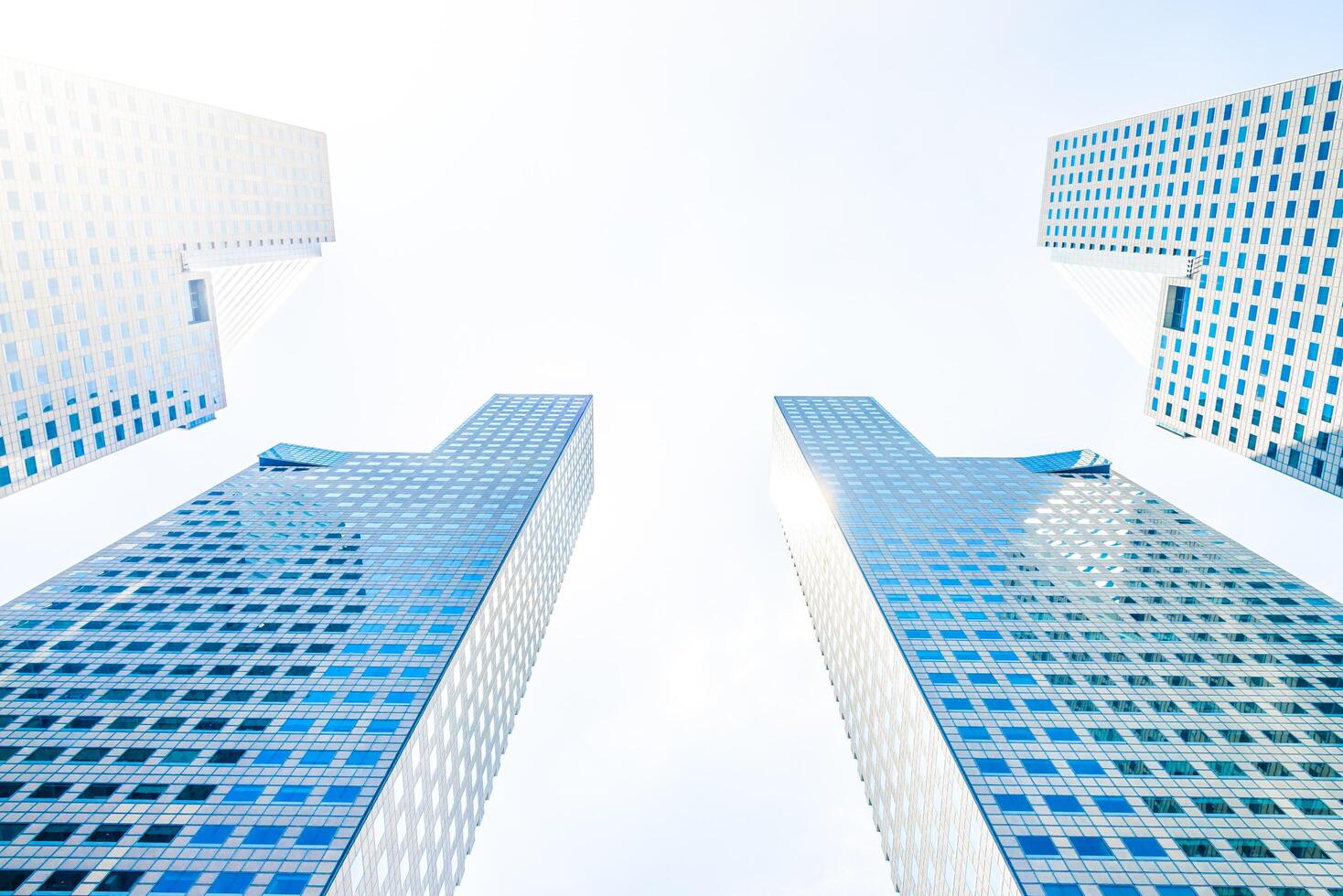 Two tall buildings with windows and sky in the background photo