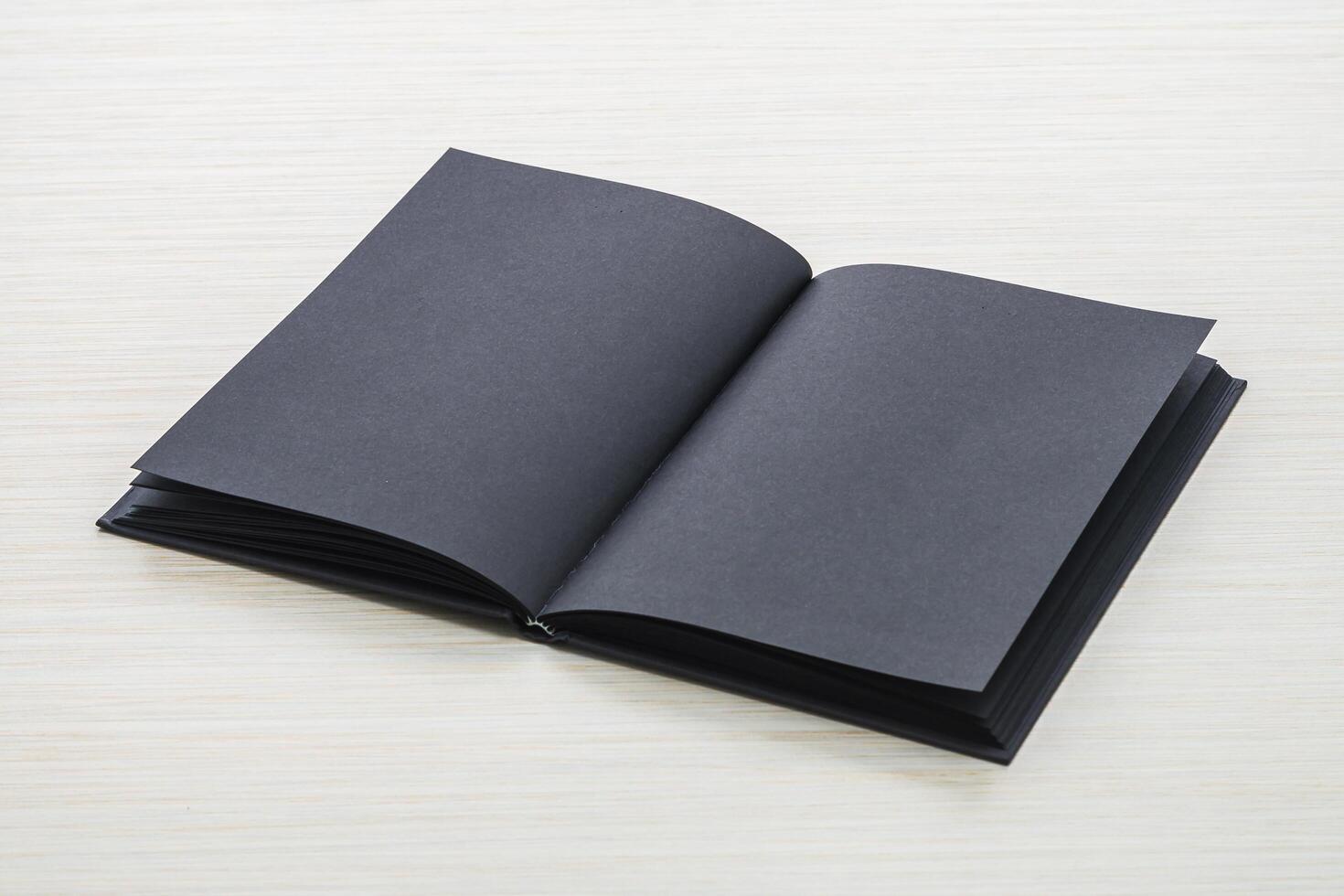 An open black book on a white table photo