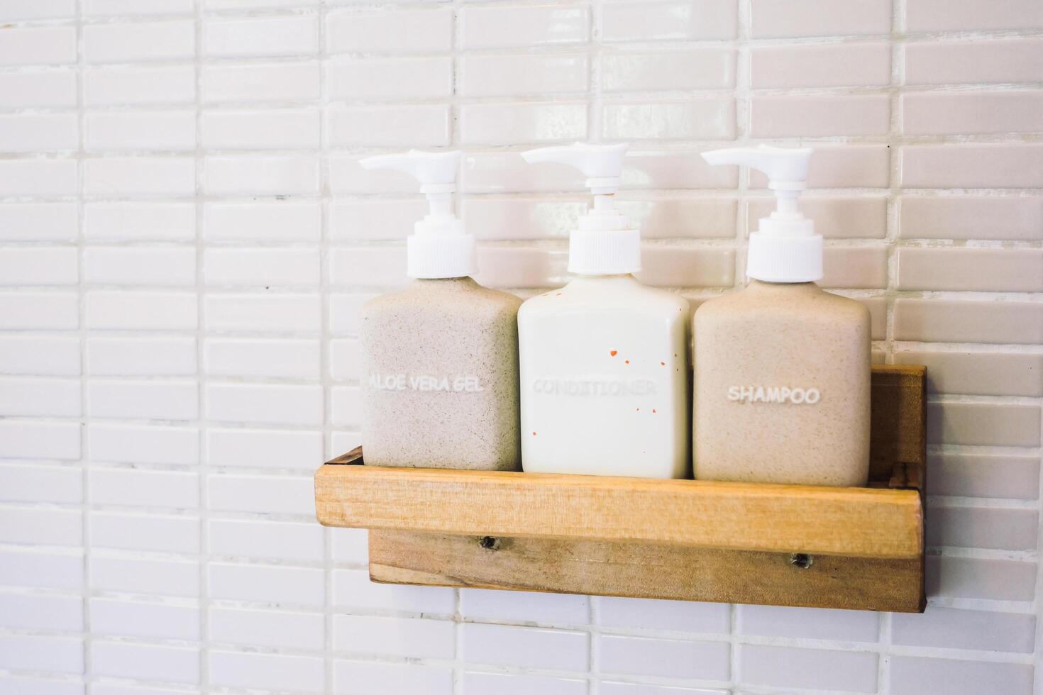 A wooden shelf holding three bottles of soap photo