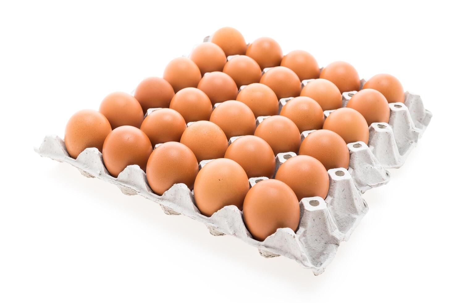 A dozen eggs in a carton on a white background photo