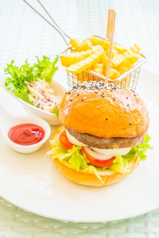 A hamburger and fries on a plate photo