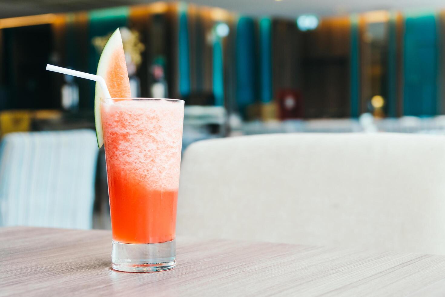 A glass of watermelon juice with a straw photo