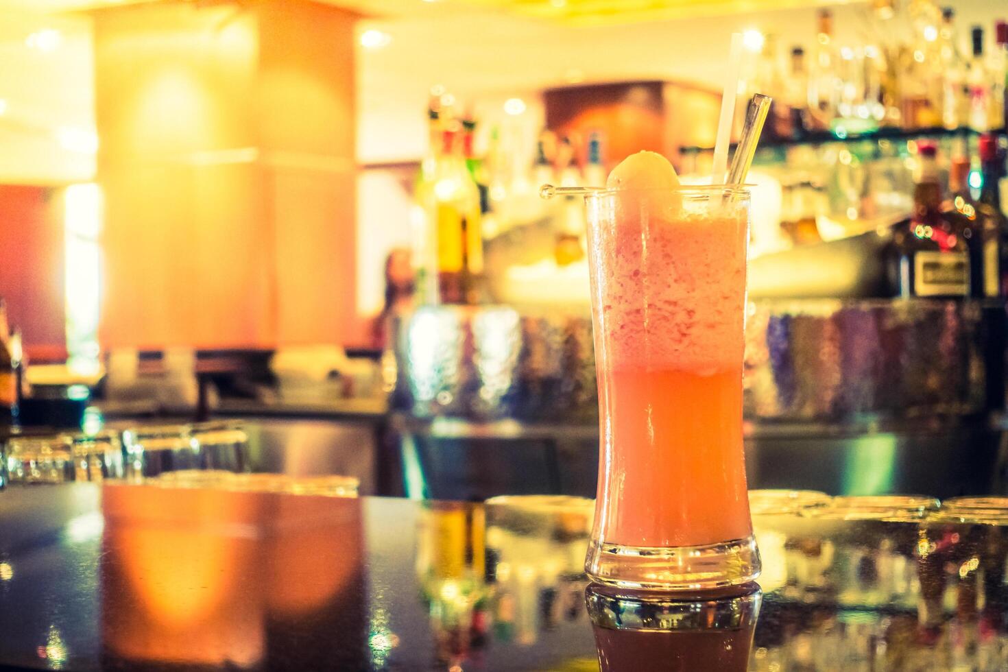 A pink drink sitting on a bar counter photo