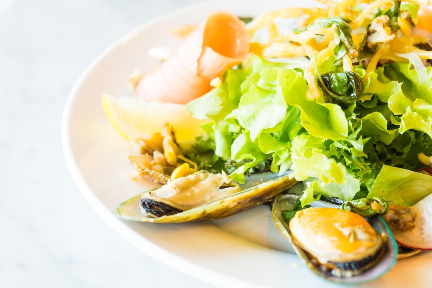 A plate of food with a salad and mussels photo
