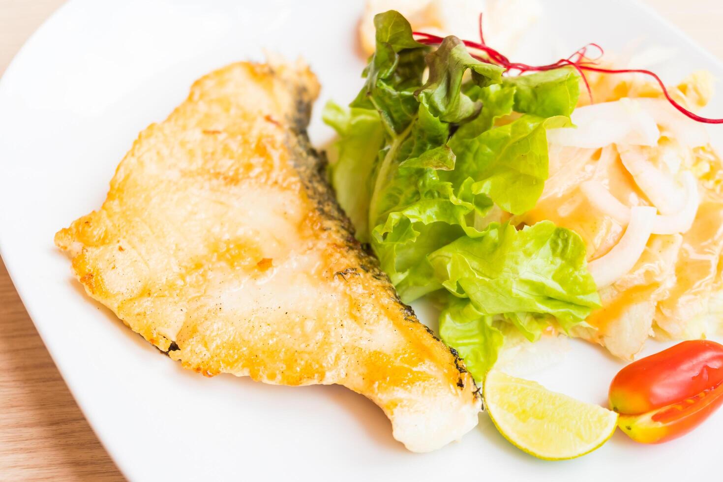 A plate with fish and vegetables on it photo