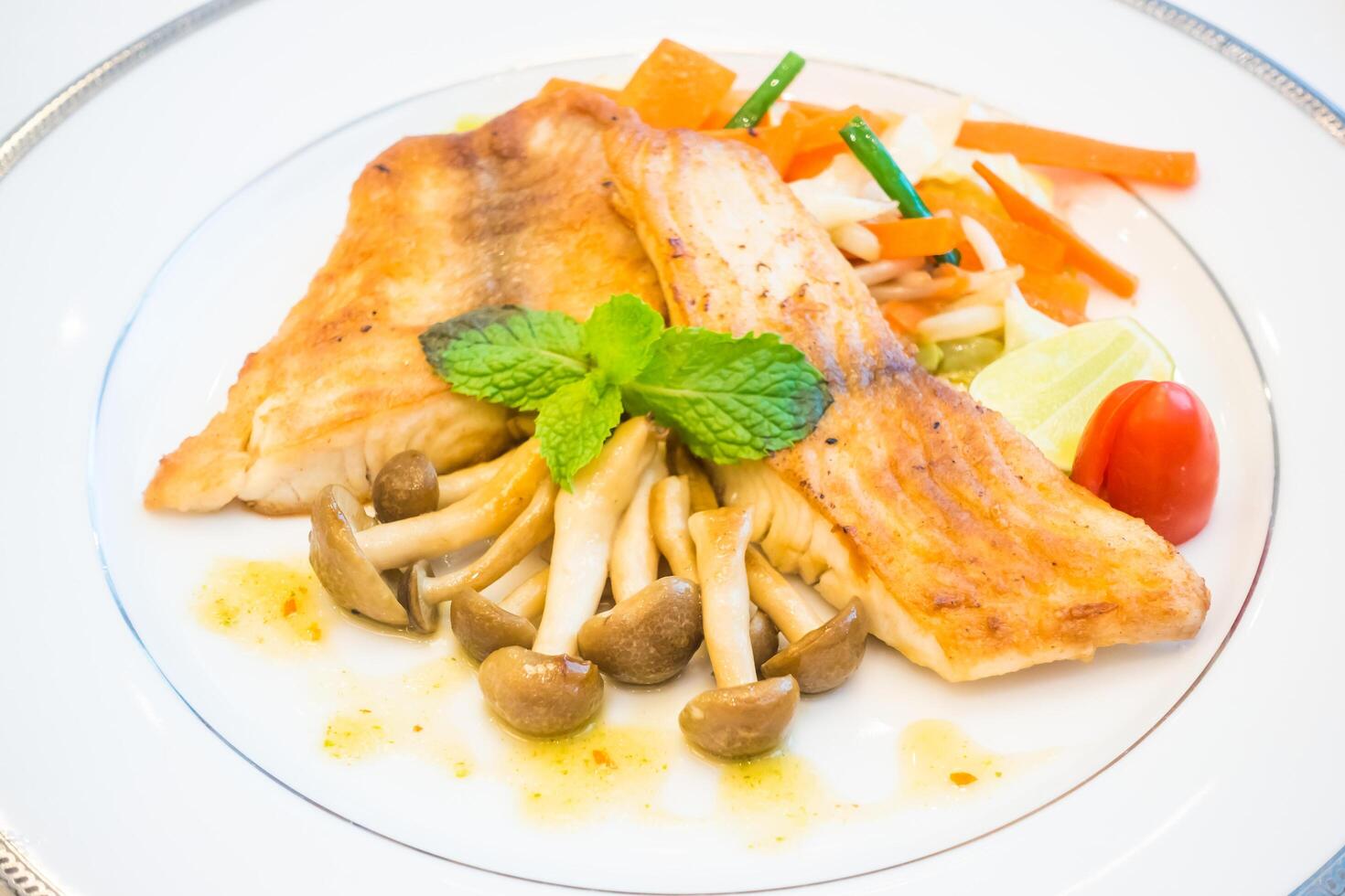 A plate with fish, mushrooms and vegetables photo