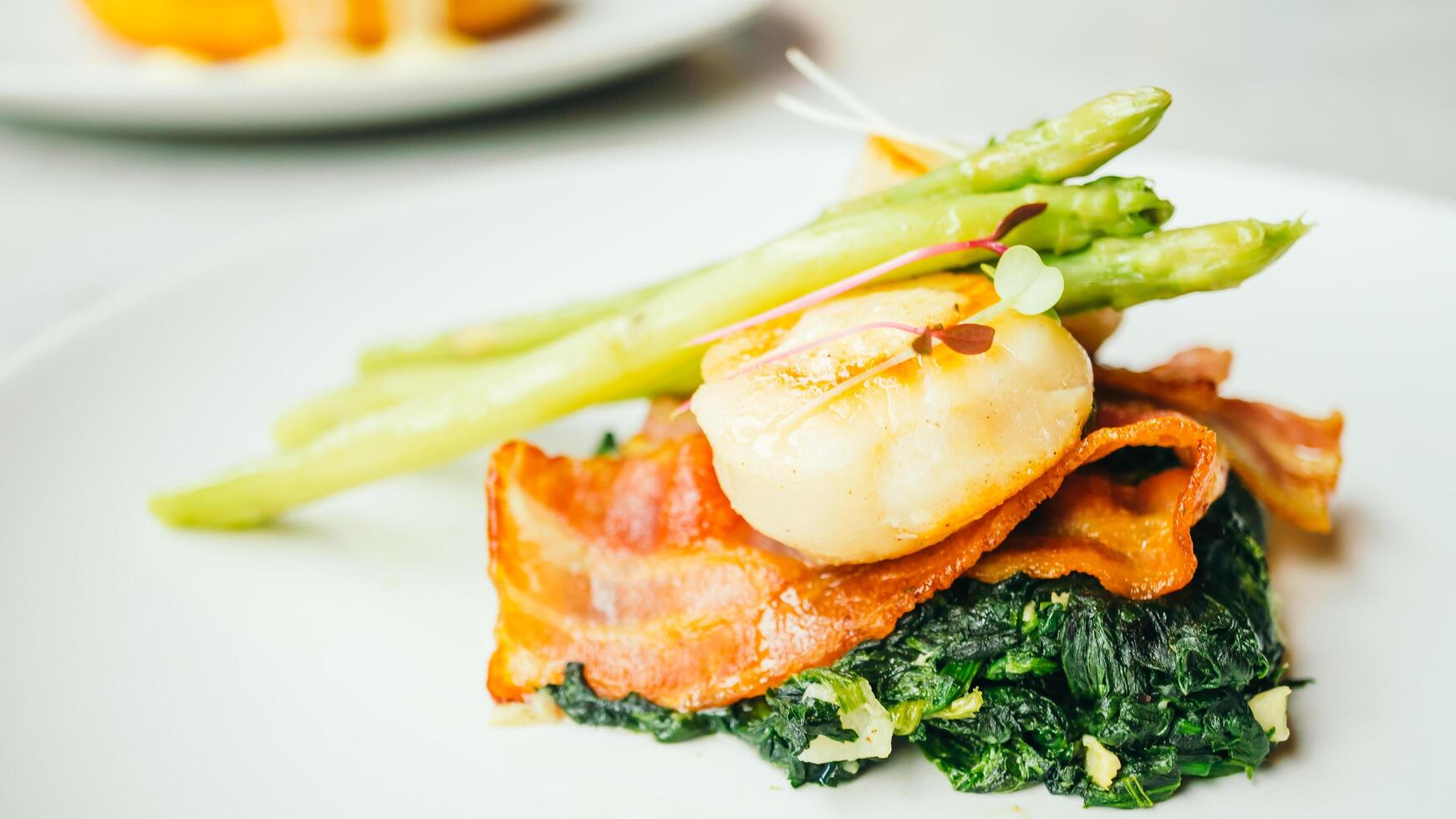 A plate with asparagus, bacon and scallops photo